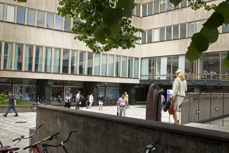 Näkymä Porthania-rakennukseen Yliopistonkadun ja Fabianinkadun risteyksestä liikkuvilla ihmisillä