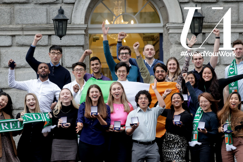 A group of students on a staircase, celebrating the awards they have received.