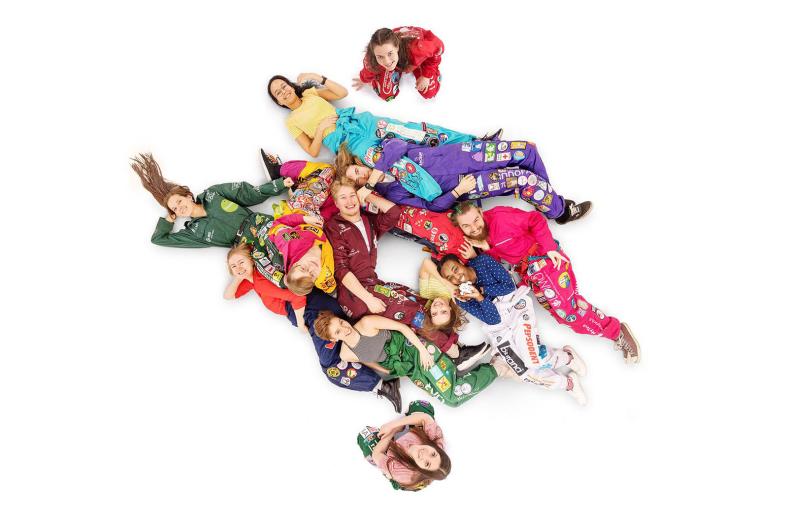 Haalareihin pukeutuneita opiskelijoita asettuneena yliopiston liekkimerkin muotoon.