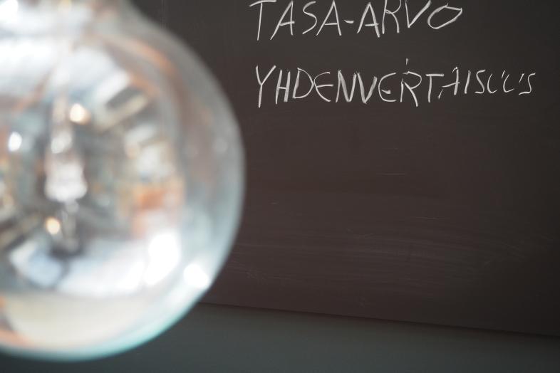 Liitutaulu, johon kirjoitettu sanat "tasa-arvo" ja "yhdenvertaisuus".