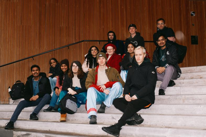 A group of students sitting on the steps of Think Corner's entrance on the City Centre Campus.
