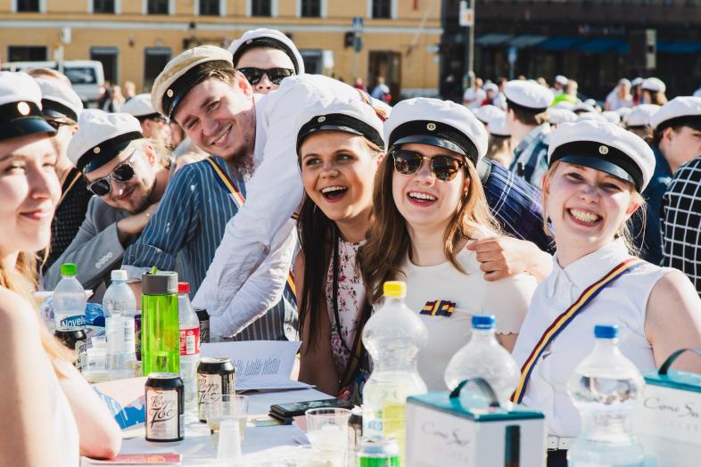 Ylioppilaslakkeihin pukeutuneita opiskelijoita Senaatintorilla sitsaamassa.