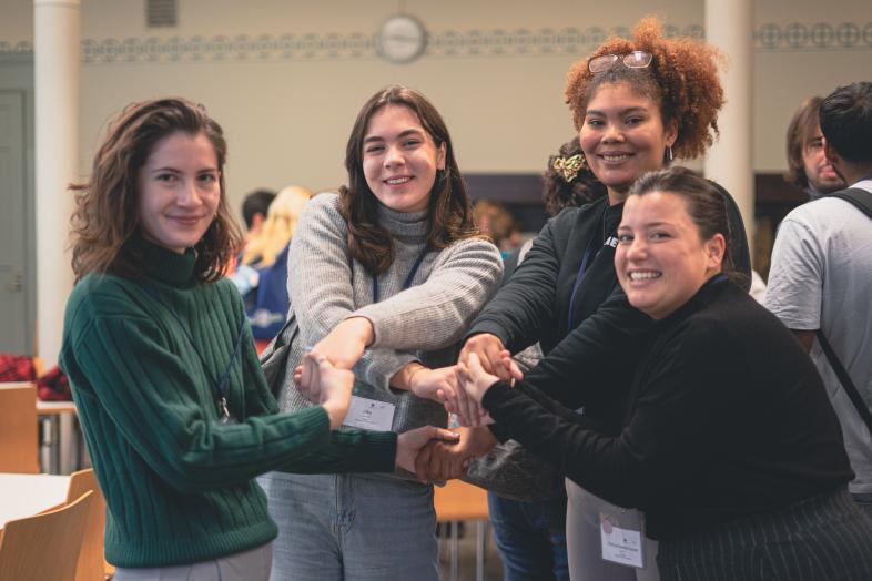 Neljä opiskelijaa pitää käsistään kiinni