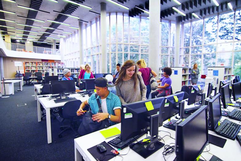 Opiskelijoita tietokoneiden ääressä.