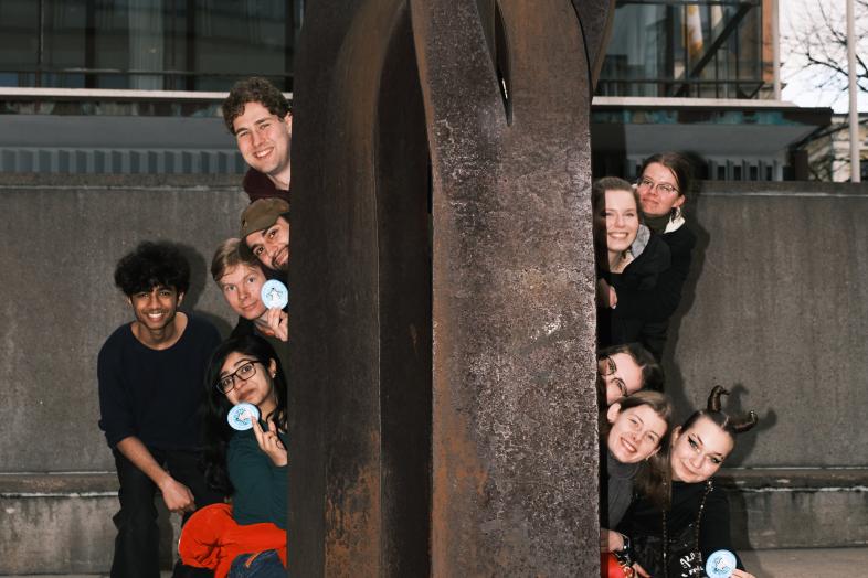 Tuutorit kurkistaa patsaan takaa