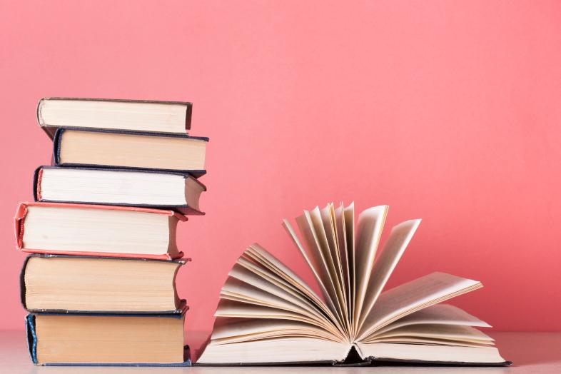 Kirjoja vaaleanpunaista taustaa vasten