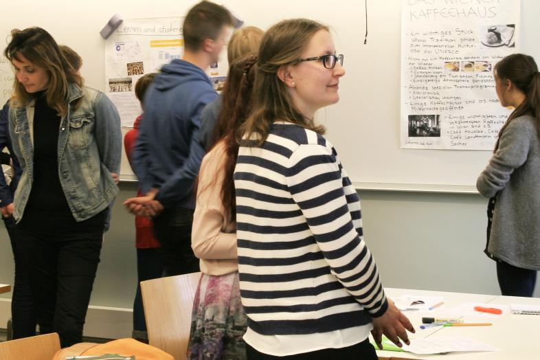 Opiskelijoita seisomassa luokassa.