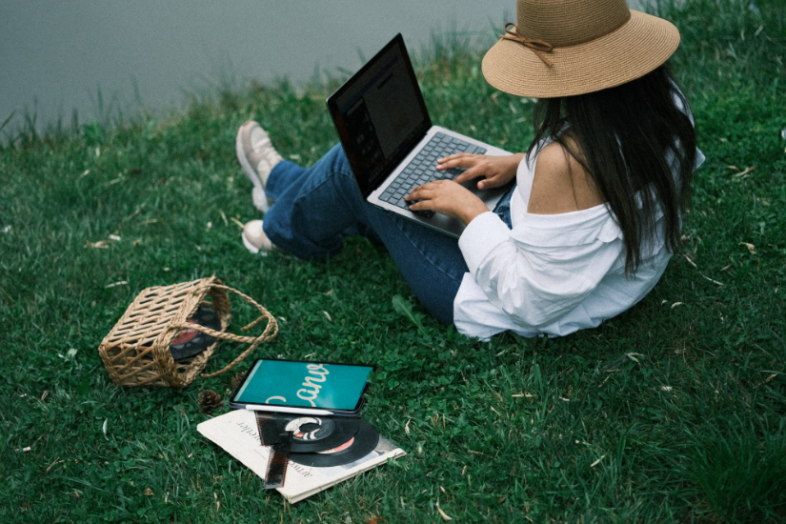 The girl is working on a laptop.